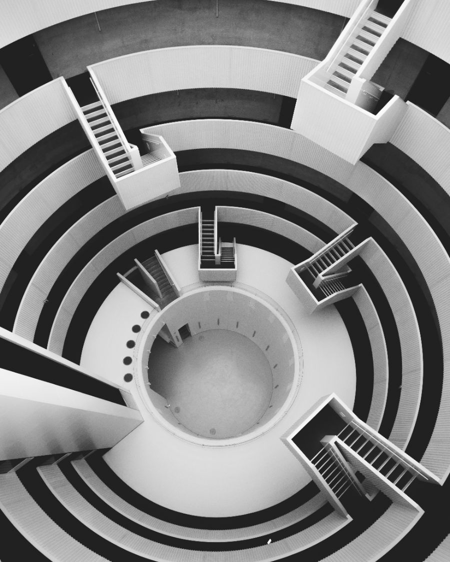 Concentric white stairways in a circular atrium seen from above