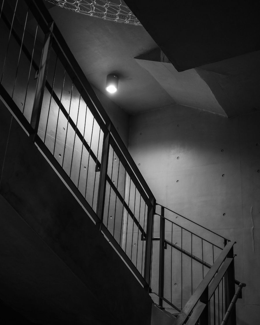 A concrete stairwell lit by a single bulb