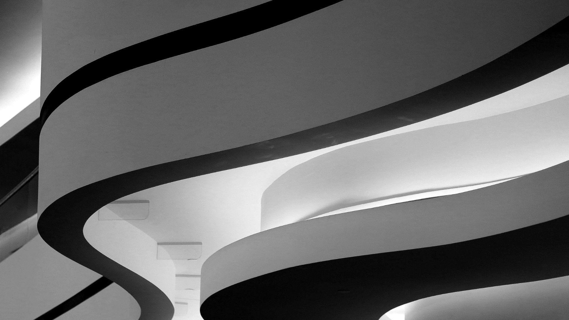 Sweeping white curved balconies of a modern building, in black and white