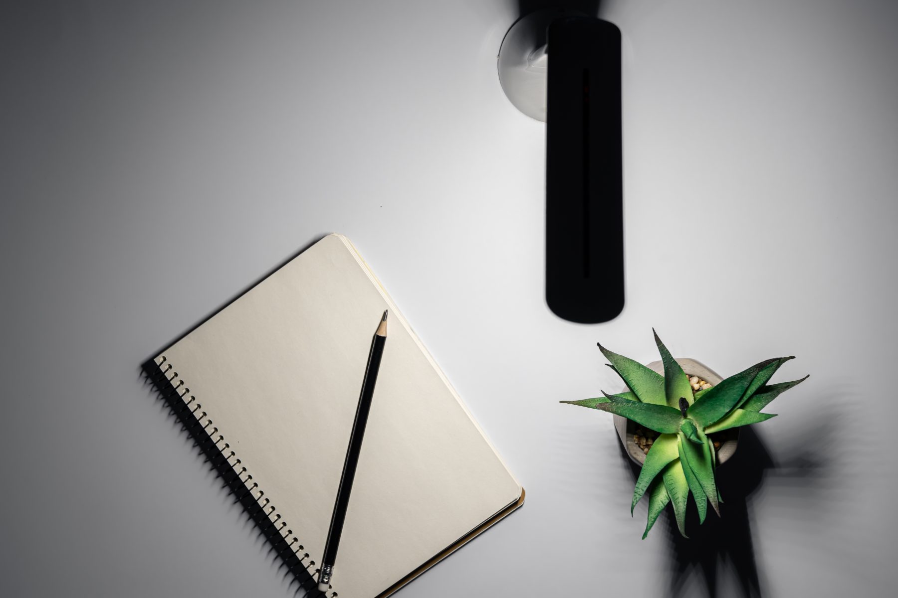 A notepad beside a desk lamp at night